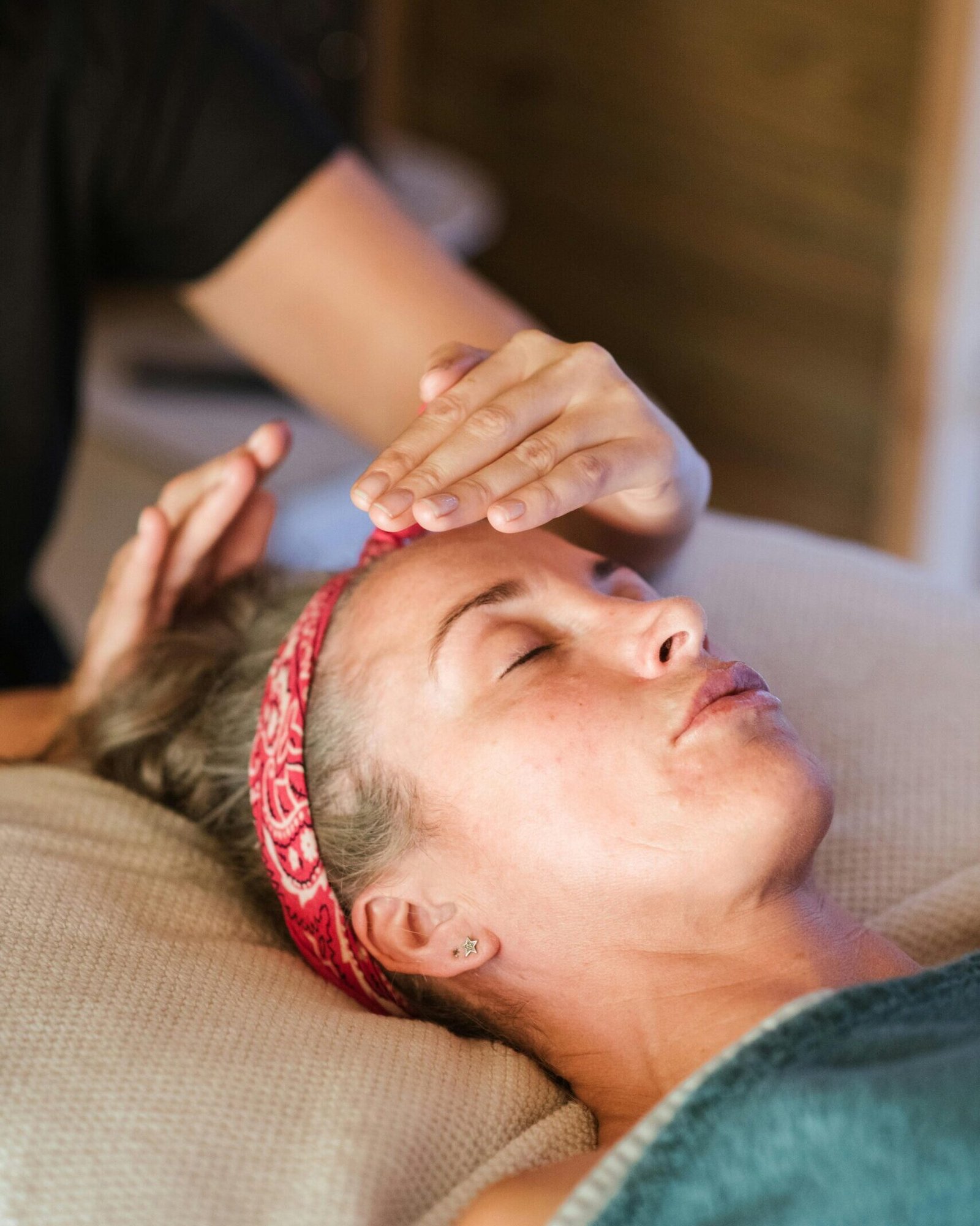 A woman enjoying a peaceful reiki session in a cozy spa setting for ultimate relaxation.